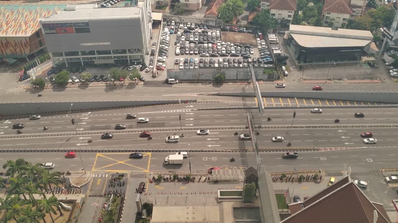 A 12-lane road in Kuala Lumpur is shown in this aerial view. Heavy traffic moves quickly across the wide highway within the bustling Malaysian metropolis