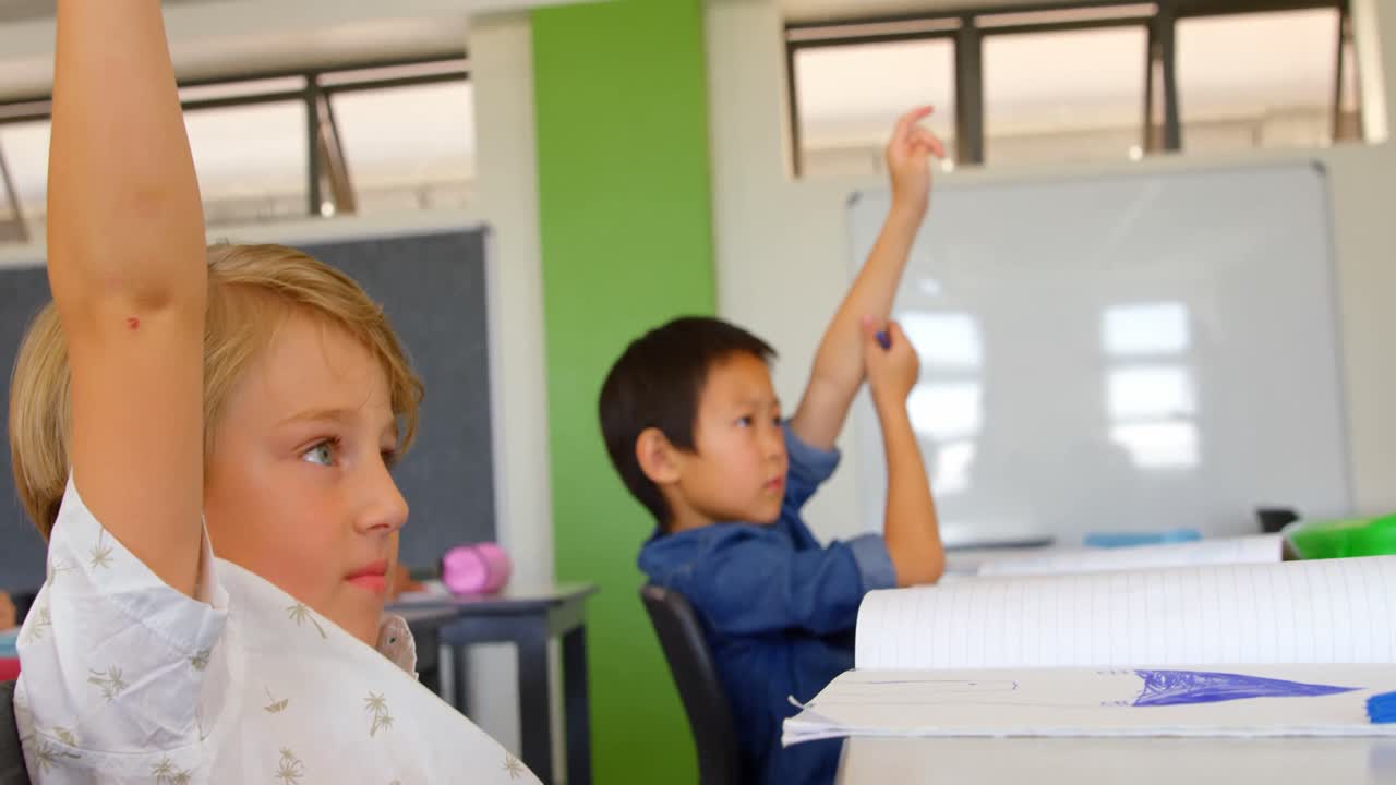 다민족 학교 소년 들 이 학교 의 교실 에서 손 을 들고 있다 4k