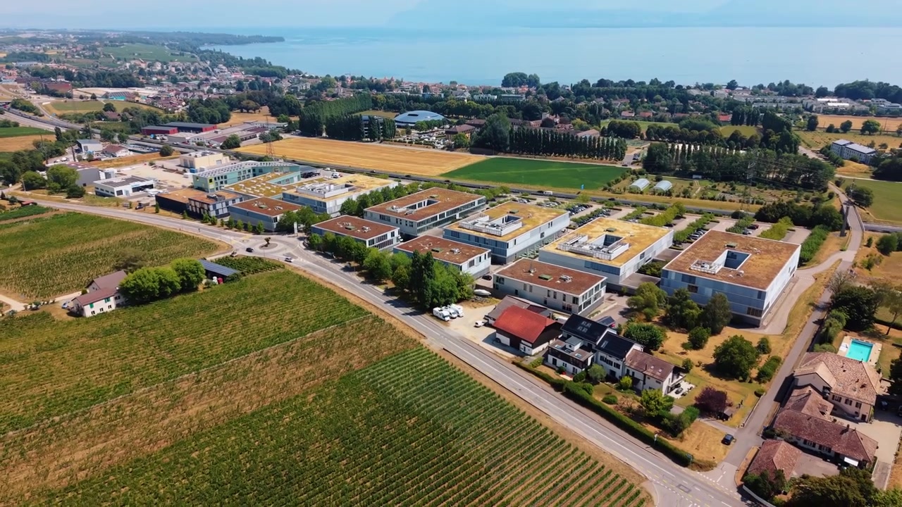 Gli edifici del parco commerciale si ergono vicino al Lago di Ginevra mentre il drone si allontana e si sposta