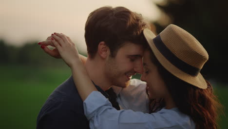 una pareja sensual bailando en cámara lenta en el parque al atardecer.