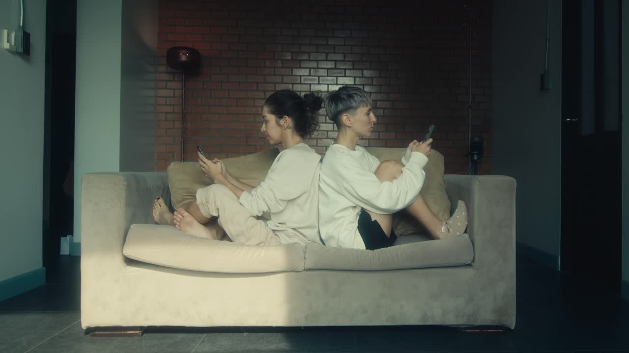 Two Women on a Couch, Back to Back, Using Phones