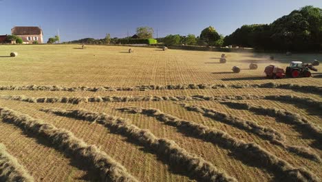 aerial view of tractor harvesting straw bales.