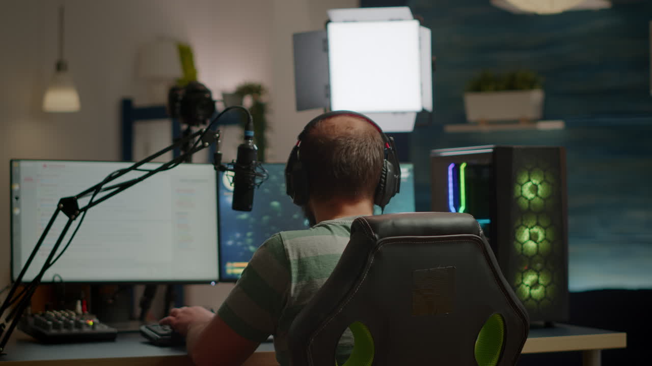 Back shot of streamer man playing on powerful computer shooter video game