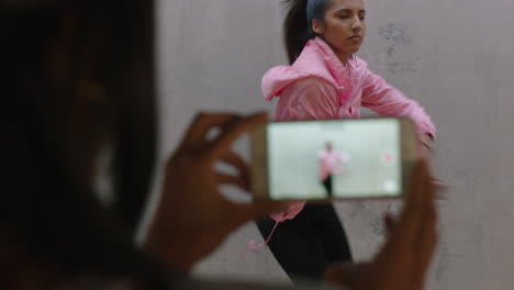 dancing-woman-happy-freestyle-dancer-friend-using-smartphone-taking-video-enjoying-sharing-hip-hop-dance-on-social-media-in-grungy-urban-warehouse