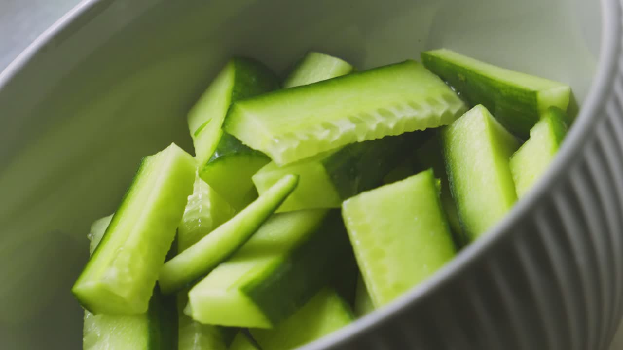 Fresh Organic Cucumbers Cut Up in Bowl as Camera Moves Slowly Around. Healthy Eating Fibre Rich Food. Used as Garnish in Salads or Wraps.