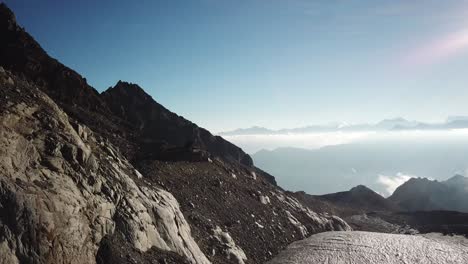 drone push in: landscape in the swiss alps during a sunrise, rocky steep mountains and white glacier