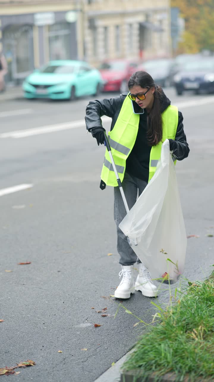 mujer limpiando la basura en la calle
