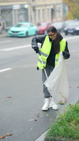 woman cleaning up trash on the street