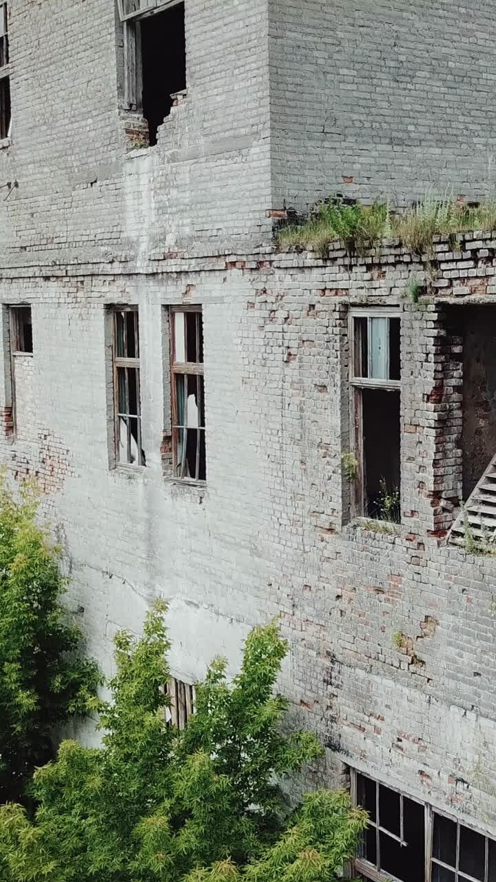 Fábrica abandonada. Antigo edifício industrial para demolição. Vista aérea. Vídeo vertical.