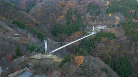 aerial drone flight over high above suspension bridge in japanese countryside