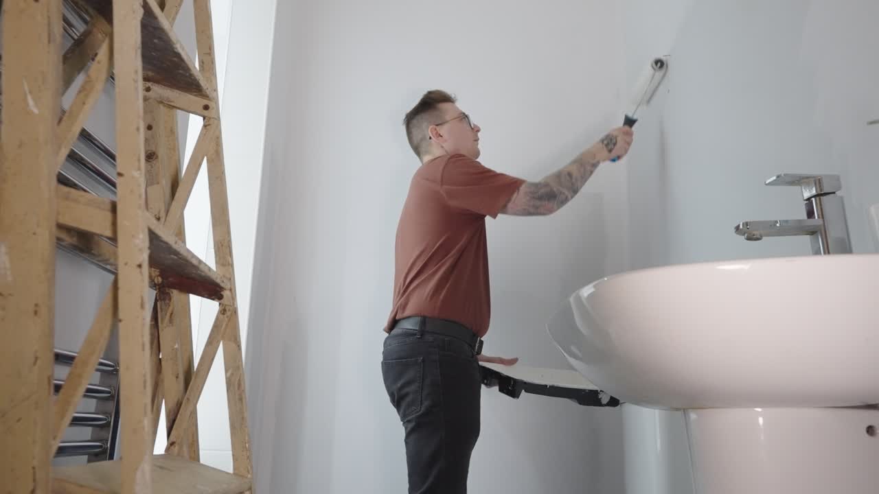 rodillo en la mano, y la pintura en la bandeja, listo para iluminar el baño hoy