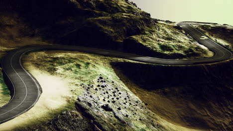 winding road through rocky terrain under a dramatic sky at dusk