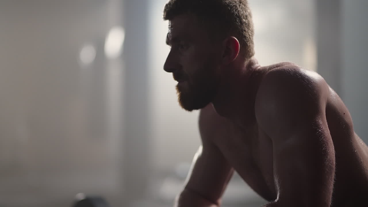 Beautiful Athletic man Wipes Sweat from His Forehead with a Hand Looks into Camera. He's Tired after Intensive Cross Fitness Exercise