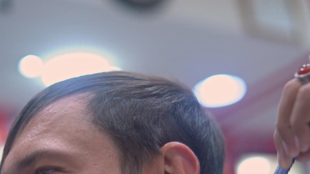 이발사 가 가위 로 남자 의 머리 를 잘라낸다