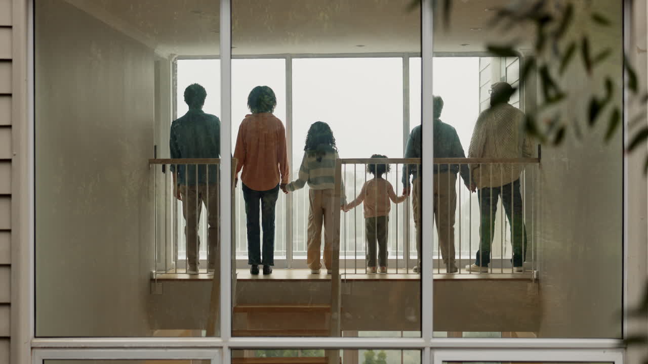 가족 들 이 함께 서서 창문 밖 을 바라보고 있다