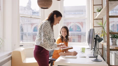 Business-woman-using-tablet-app-showing-3d-printed-model-of-geodesic-dome-walking-through-modern-office-to-diverse-team-meeting