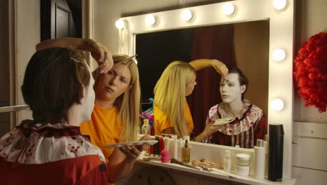 makeup artist applying clown makeup for a halloween event