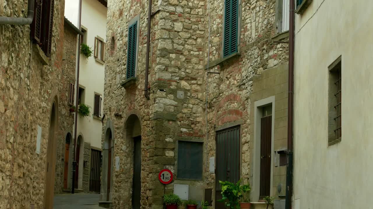 이탈리아 스카니의 키안티 지방에 있는 마을 라다의 조용한 주거 지역의 돌로 된 전면의 기울기를 설정합니다.