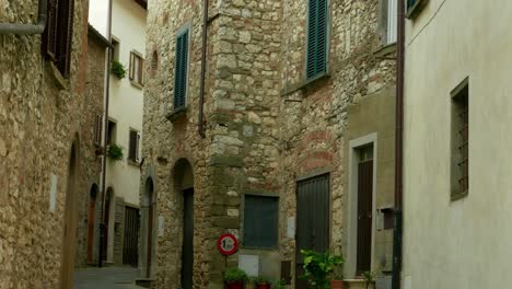 establishing shot tilt up of the stone facade of a quiet residential area of radda, a village in the chianti region of tuscany, italy