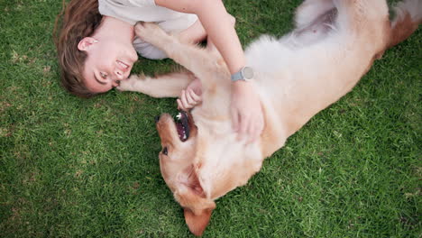 woman playing with her golden retriever in the grass