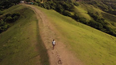 a man walking on top of a hill in batanes