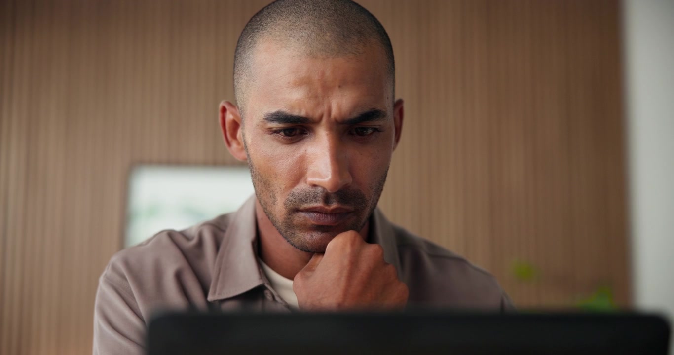 Focused Man Working on Laptop in Modern Office