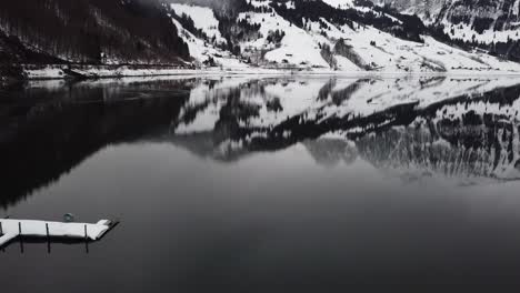 Close-backward-flight-to-the-water,-past-a-floating-raft-with-snow-on-it