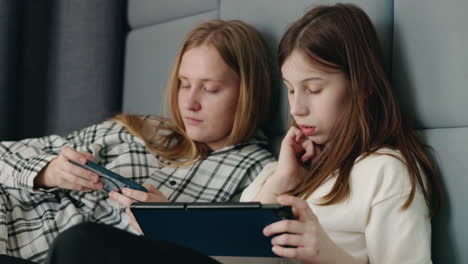 teenage sisters spending time together on devices