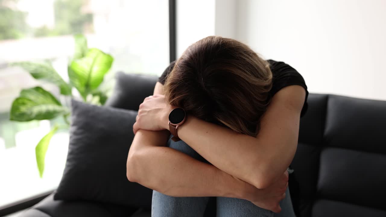 Woman suffering from pain or emotional distress on a couch