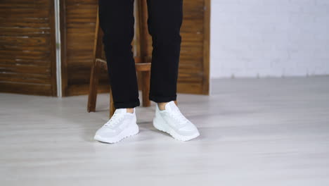 Dancing in a new white comfortable sneakers with laces. Female model jumps to demonstrate fashionable sport footwear.