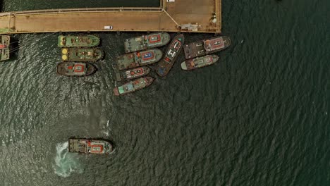 top down aerial view of tug boats moored at the pier in taganito waiting to assist nickel asia mining barges