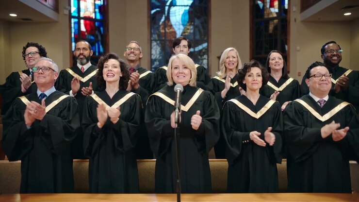 Stepping lead singer to mic, choir clapping, singing to lead worship at church front, black robes