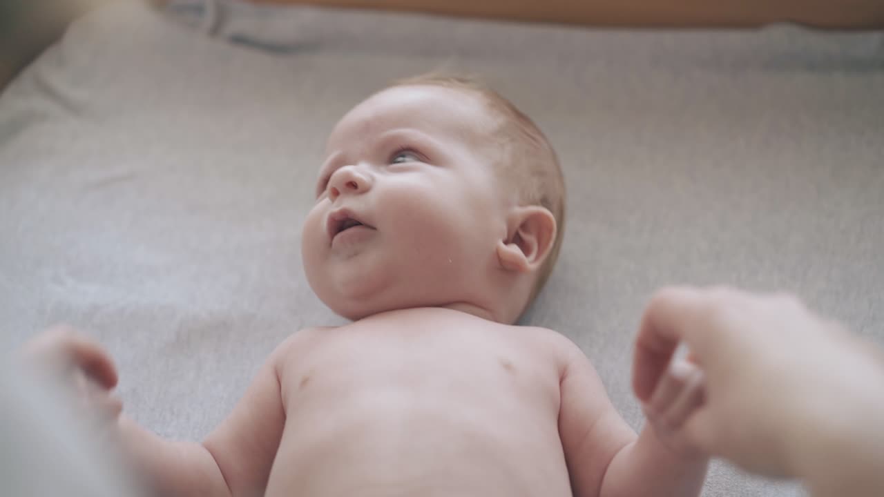niño con cabello corto se acuesta en la mesa y la enfermera hace masaje