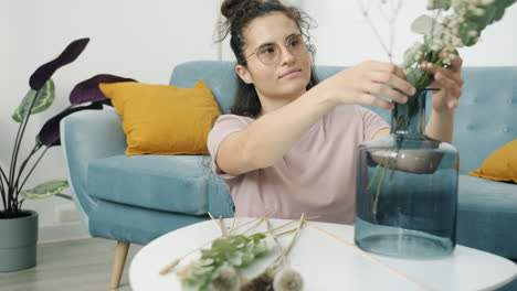 woman arranging flowers at home