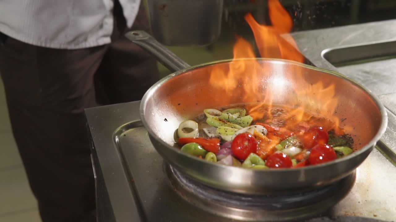 chef cocinando verduras en una sartén