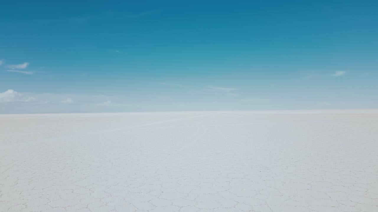 Experience the awe-inspiring natural beauty of Bolivia's Salar de Uyuni in the daylight with mesmerizing drone footage showcasing the vast expanse of the endless salt flats from above