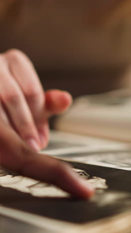 white woman with african-american husband touches baby picture of relative looking at old photo-book in living room closeup slow motion