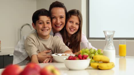madre feliz con sus hijos tomando su desayuno