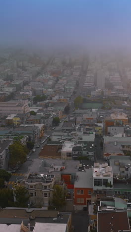 flying over the residential area of beautiful san francisco at sundown. thick fog covering quickly the city. top view. vertical video