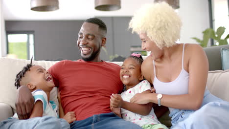 un homme, une femme et leurs enfants partagent la joie à la maison.