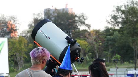 people observing sky through a telescope outdoors