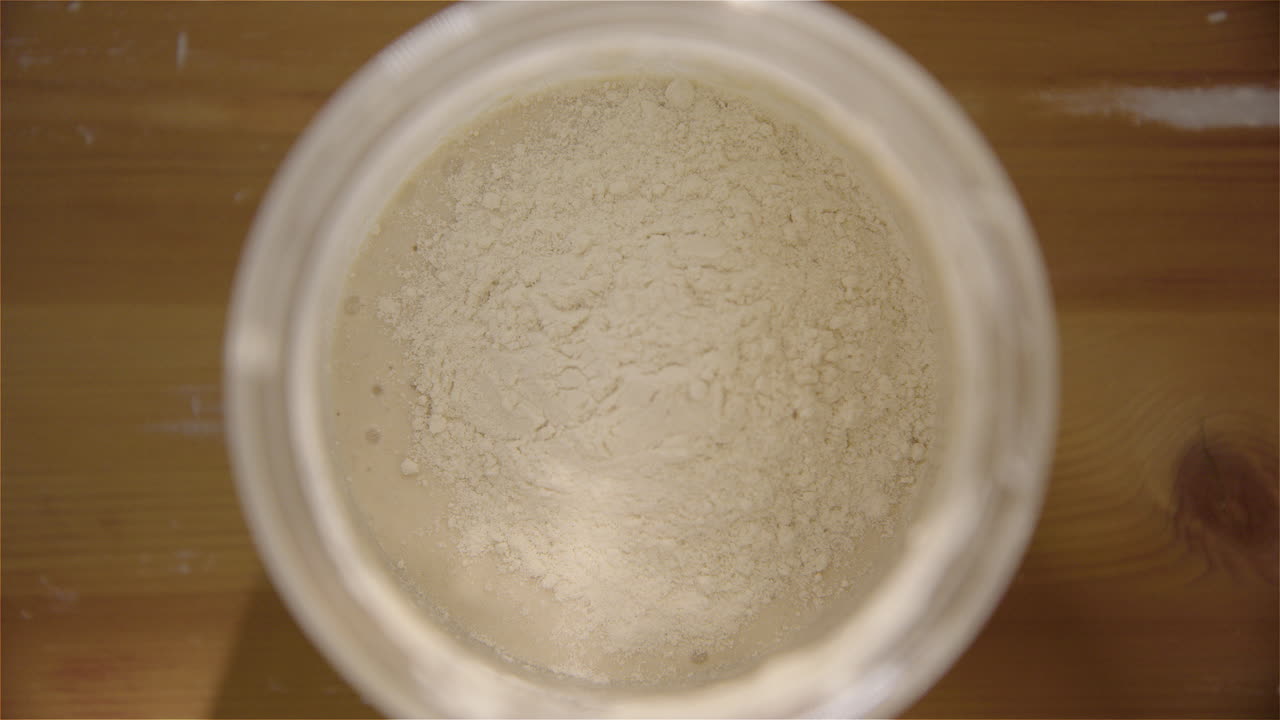 하향식 - 사워도우 스타터에 밀가루와 물을 공급합니다.