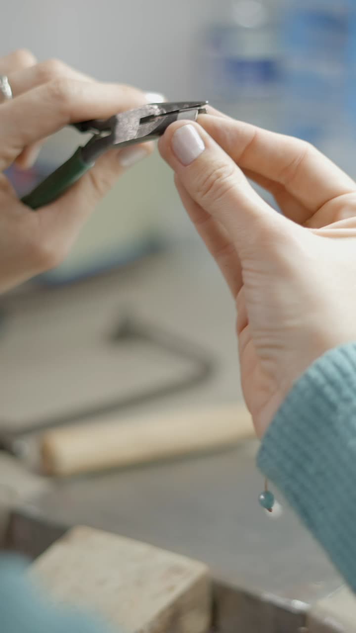 Close-up of hands crafting jewelry with tools