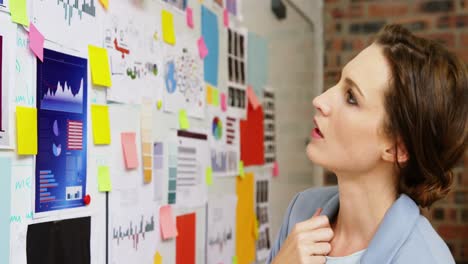 Female-business-executive-looking-at-a-whiteboard