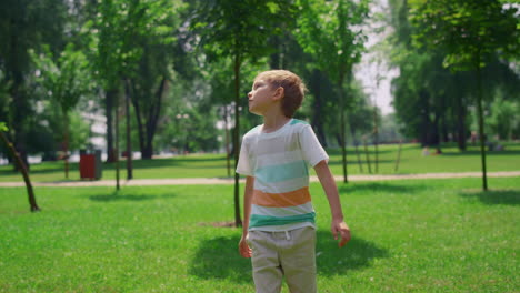 joyful boy watching badminton game. happy child looking up on shuttlecock.