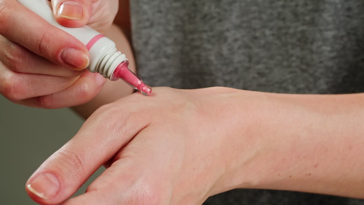 aplicación de crema rosada en la muñeca
