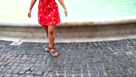 smiling female tourist tries her luck in trevi fountain, rome, italy