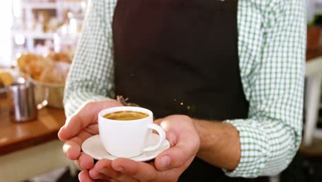 waiter holding cup of coffee