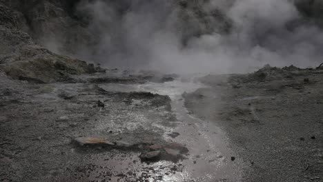 boiling hot geothermal volcanic mud pool, closeup shot steamy lake bubbling mud and steam landscape