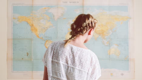 tourist woman looking at world map planning travel adventure